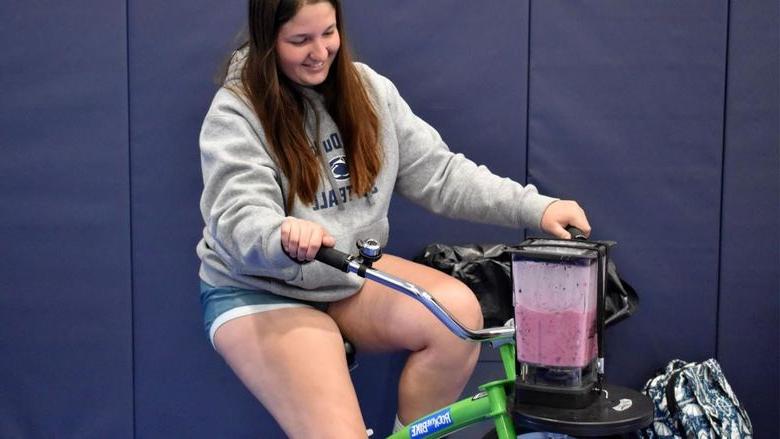 买球网站杜波依斯分校 student Aleigha Geer pedals the smoothie bike during the 2023 Earth Day celebration at the PAW Center.