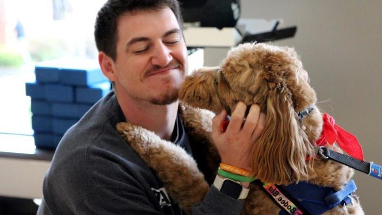 买球网站杜波依斯分校 third-year student Jeff Romano enjoys the comfort a therapy dog gives him during one of the events of De-Stress Fest at 买球网站杜波依斯分校.